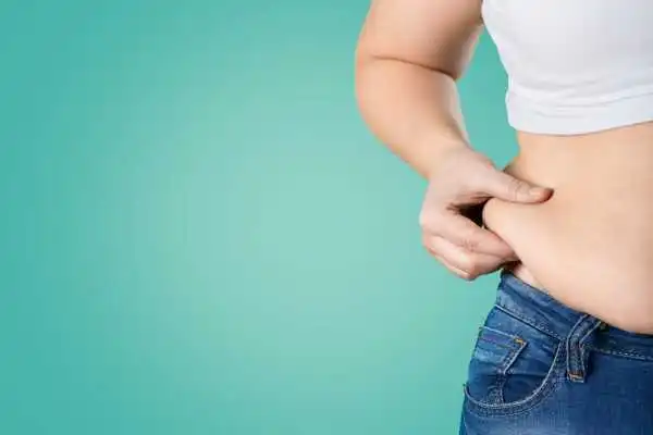 Image of woman pinching her love handles to show weight gain Corby